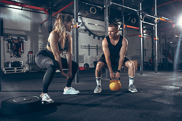 Image showing Beautiful young sporty couple training, workout in gym together