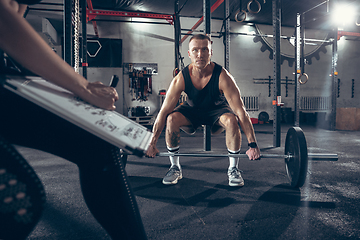 Image showing Beautiful young sporty couple training, workout in gym together