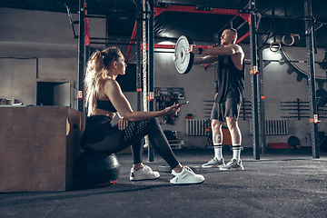 Image showing Beautiful young sporty couple training, workout in gym together