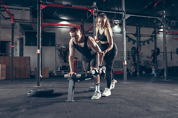 Image showing Beautiful young sporty couple training, workout in gym together