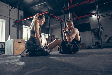 Image showing Beautiful young sporty couple training, workout in gym together