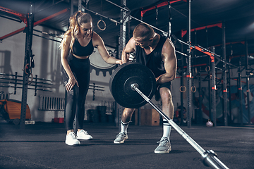 Image showing Beautiful young sporty couple training, workout in gym together