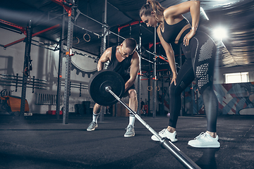 Image showing Beautiful young sporty couple training, workout in gym together