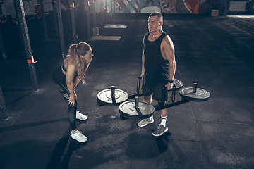 Image showing Beautiful young sporty couple training, workout in gym together