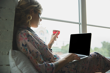 Image showing Portrait of pretty young girl in modern apartment in the morning. Resting, calm, salisfied. Youth and wellness concept.