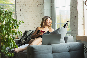 Image showing Portrait of pretty young girl in modern apartment in the morning. Resting, calm, salisfied. Youth and wellness concept.