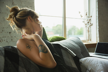 Image showing Portrait of pretty young girl in modern apartment in the morning. Resting, calm, salisfied. Youth and wellness concept.