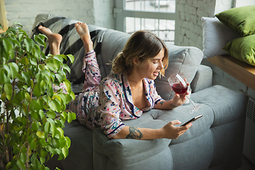 Image showing Portrait of pretty young girl in modern apartment in the morning. Resting, calm, salisfied. Youth and wellness concept.