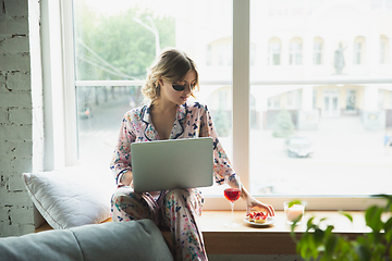 Image showing Portrait of pretty young girl in modern apartment in the morning. Resting, calm, salisfied. Youth and wellness concept.