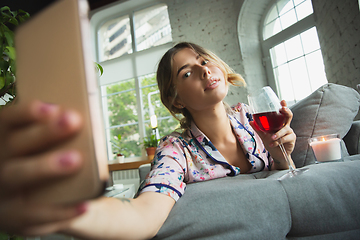 Image showing Portrait of pretty young girl in modern apartment in the morning. Resting, calm, salisfied. Youth and wellness concept.