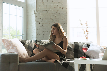 Image showing Portrait of pretty young girl in modern apartment in the morning. Resting, calm, salisfied. Youth and wellness concept.