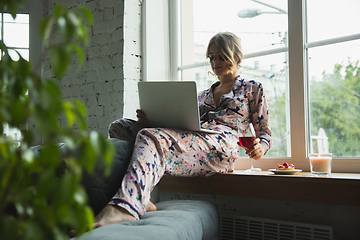 Image showing Portrait of pretty young girl in modern apartment in the morning. Resting, calm, salisfied. Youth and wellness concept.