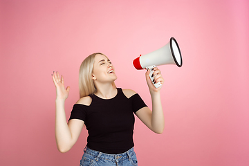 Image showing Portrait of young caucasian woman with bright emotions on coral pink studio background