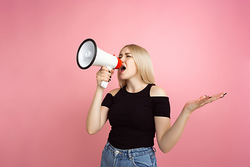 Image showing Portrait of young caucasian woman with bright emotions on coral pink studio background