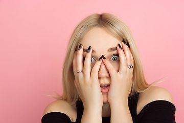 Image showing Portrait of young caucasian woman with bright emotions on coral pink studio background