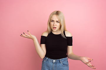 Image showing Portrait of young caucasian woman with bright emotions on coral pink studio background