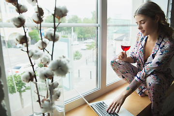 Image showing Portrait of pretty young girl in modern apartment in the morning. Resting, calm, salisfied. Youth and wellness concept.