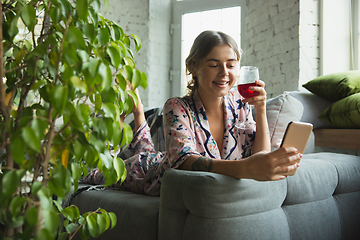 Image showing Portrait of pretty young girl in modern apartment in the morning. Resting, calm, salisfied. Youth and wellness concept.