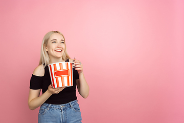 Image showing Portrait of young caucasian woman with bright emotions on coral pink studio background