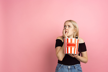 Image showing Portrait of young caucasian woman with bright emotions on coral pink studio background