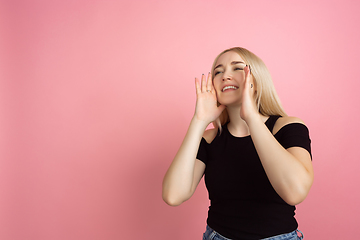 Image showing Portrait of young caucasian woman with bright emotions on coral pink studio background