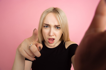 Image showing Portrait of young caucasian woman with bright emotions on coral pink studio background