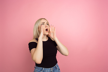 Image showing Portrait of young caucasian woman with bright emotions on coral pink studio background