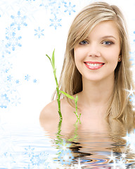 Image showing blue-eyed blonde with bamboo in water