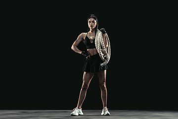 Image showing Beautiful young female athlete practicing on black studio background, full length portrait