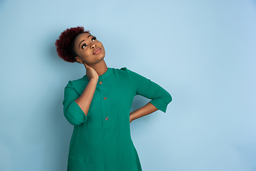 Image showing African-american beautiful young woman\'s portrait on blue studio background, emotional and expressive. Copyspace for ad.