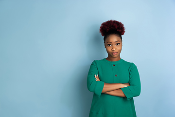 Image showing African-american beautiful young woman\'s portrait on blue studio background, emotional and expressive. Copyspace for ad.