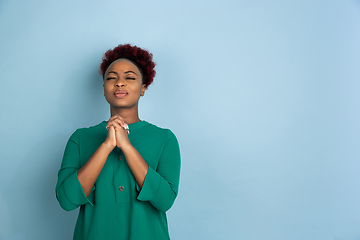 Image showing African-american beautiful young woman\'s portrait on blue studio background, emotional and expressive. Copyspace for ad.