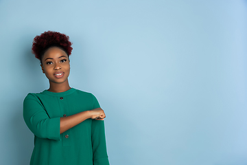 Image showing African-american beautiful young woman\'s portrait on blue studio background, emotional and expressive. Copyspace for ad.