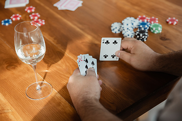 Image showing Close up group of happy mature friends playing cards and drinking wine