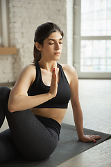 Image showing Sporty young muslim woman taking yoga lessons online and practice at home