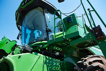 Image showing Tractor, combine at a field in sunlight. Confident, bright colors