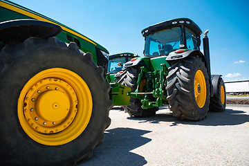 Image showing Tractor, combine at a field in sunlight. Confident, bright colors