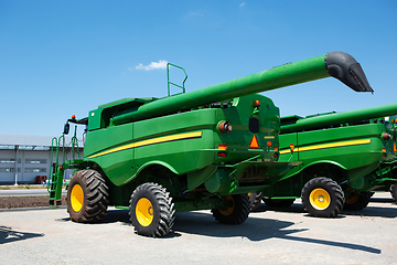 Image showing Tractor, combine at a field in sunlight. Confident, bright colors