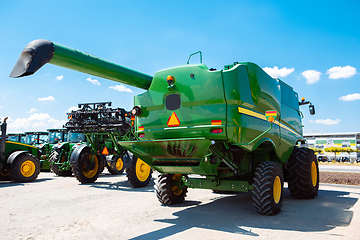 Image showing Tractor, combine at a field in sunlight. Confident, bright colors