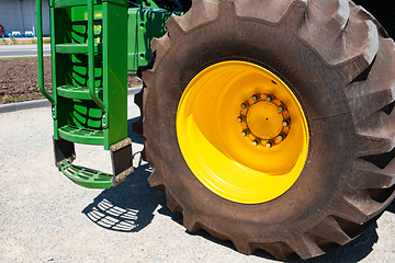 Image showing Tractor, combine at a field in sunlight. Confident, bright colors