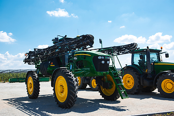 Image showing Tractor, combine at a field in sunlight. Confident, bright colors