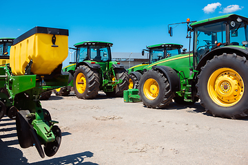 Image showing Tractor, combine at a field in sunlight. Confident, bright colors