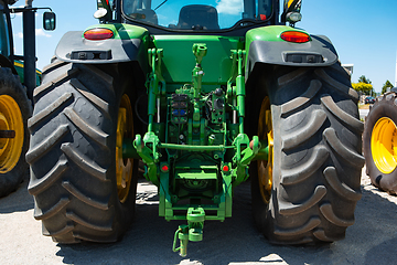 Image showing Tractor, combine at a field in sunlight. Confident, bright colors