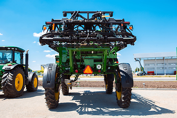 Image showing Tractor, combine at a field in sunlight. Confident, bright colors