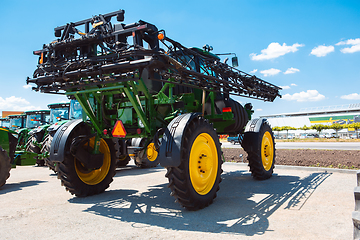 Image showing Tractor, combine at a field in sunlight. Confident, bright colors