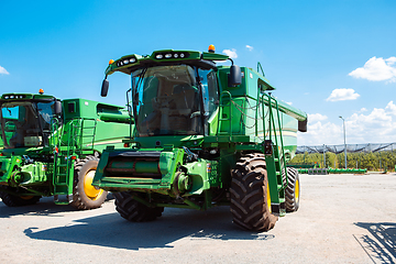 Image showing Tractor, combine at a field in sunlight. Confident, bright colors