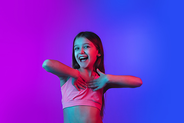 Image showing Little caucasian girl\'s portrait isolated on gradient pink-blue background in neon light.