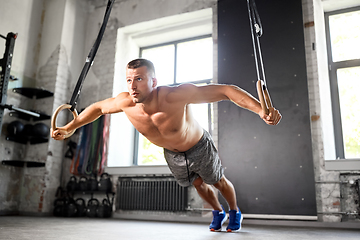 Image showing man doing exercising on gymnastic rings in gym