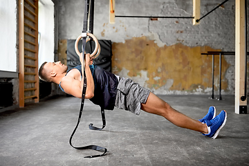 Image showing man doing exercising on gymnastic rings in gym