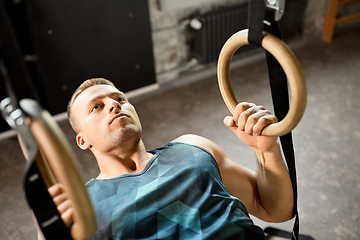 Image showing man doing exercising on gymnastic rings in gym